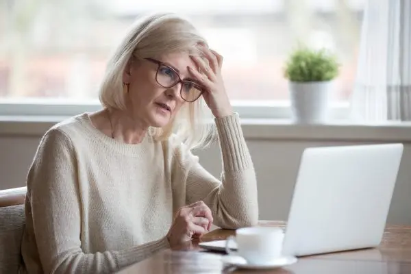 A woman sitting looking lonely at a computer